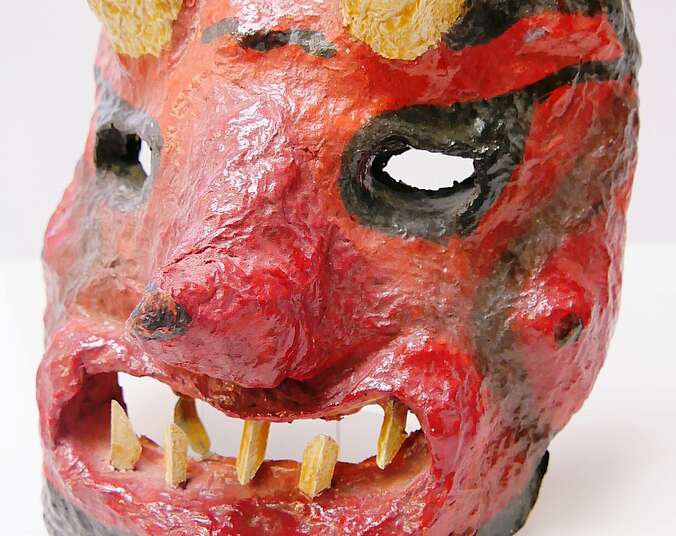 Eine Maske aus Pappmaché, die wie ein Teufel aussieht