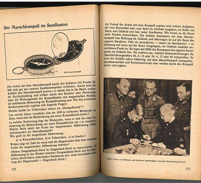 Eine Doppelseite des "Sandkastenhandbuch." auf ihr ist ein Foto von Schülern in HJ-Uniform und erwachsenen Männern in wehrmachtsuniform zu sehen, wie sie um einen Sandkasten herum stehen.