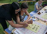 Zwei Frauen üben chinesische Kalligrafie