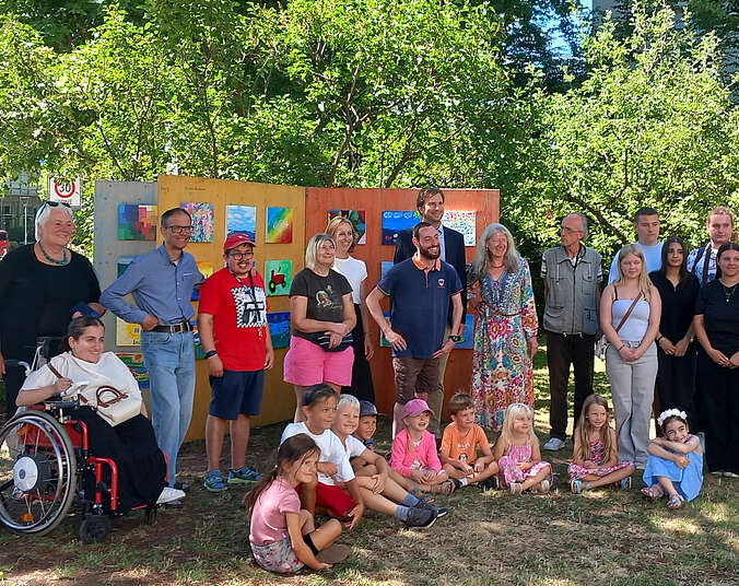 Gruppenfoto vor aufgeklappten Buchtafeln