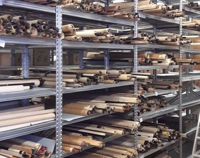 Ein Regal voller zusammengerollter Wandkarten