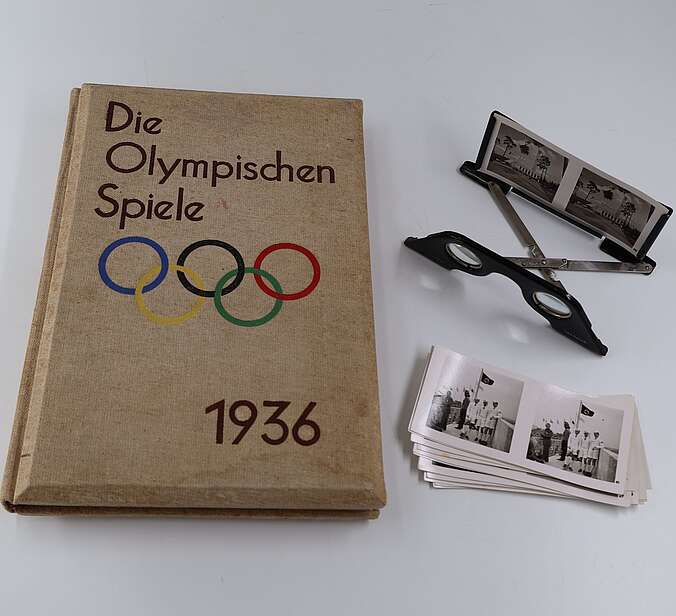 Das Buch, ein Stapel Bilder und der Stereoskopiebetrachter.
