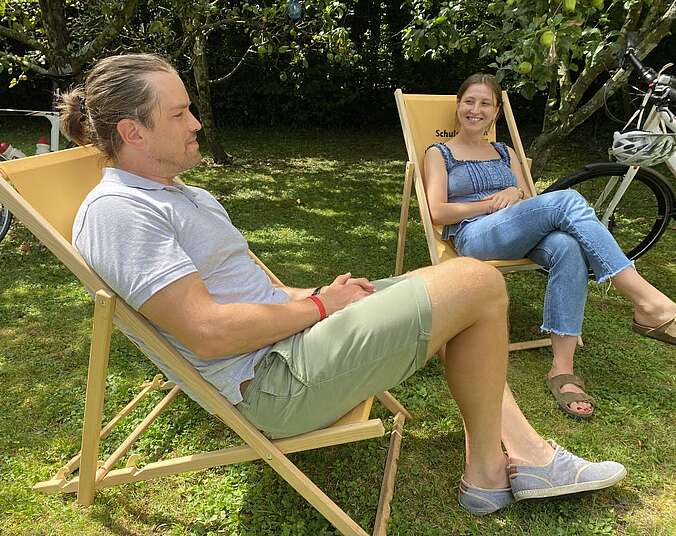 Zwei Menschen sitzen in Sonnenstühlen