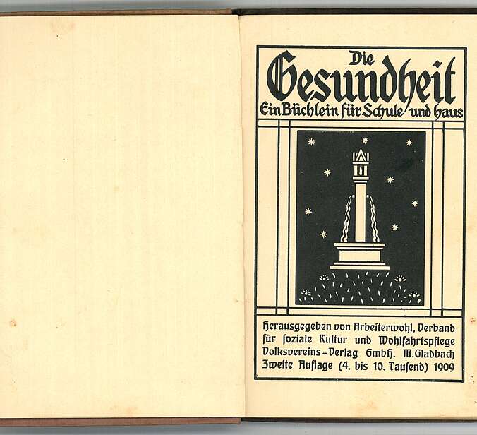 Eine aufgeschlagene Buchseite wo in schwarz gedruckt "Die Gesundheit. Ein Büchlein für Schule und Haus" steht.