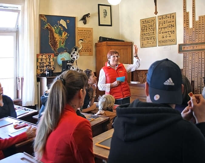 Museumsführerin steht vor Schulklasse