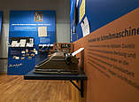 Mechanische Schreibmaschine im Vordergrund in der Ausstellung