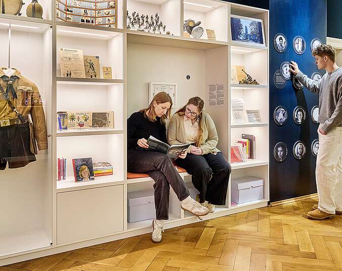 Drei junge Leute halten sich im neuen Themenraum auf.