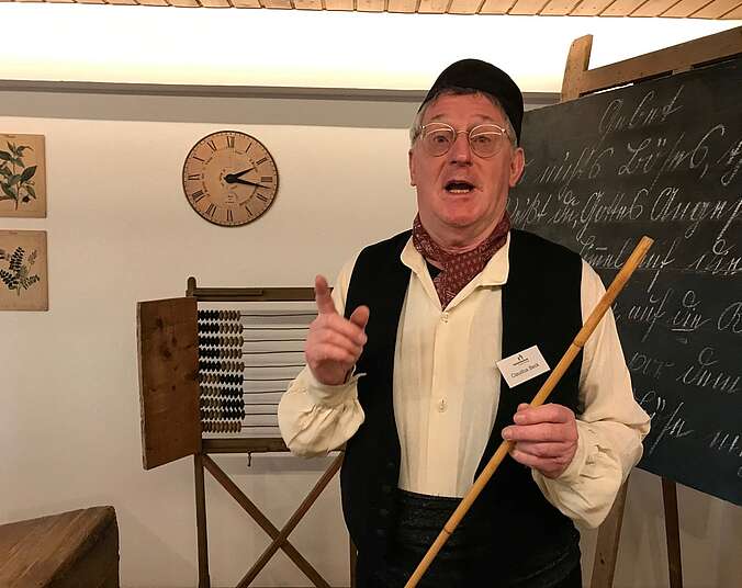 Ein Museumsführer im historischen Klassenzimmer