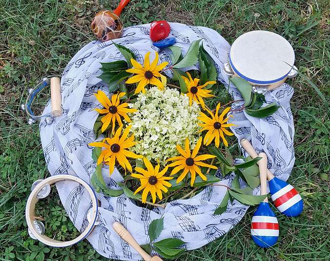 Ein Arrangement mit Blumen und verschiedenen Rhythmusinstrumenten